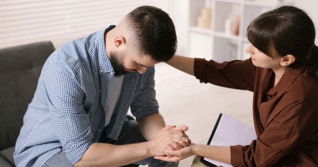 Consultório de uma psicóloga mulher tratando um paciente com Terapia Cognitiva Comportamental