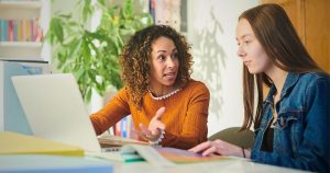 Uma mulher, orientadora vocacional ajudando uma estudante a escolher um curso