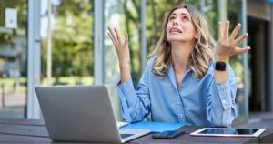 Moça loira perfeccionista trabalhando no laptop com ansiedade