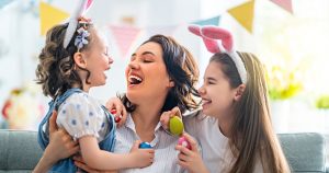 Mãe com duas filhas pequenas celebrando a Páscoa.