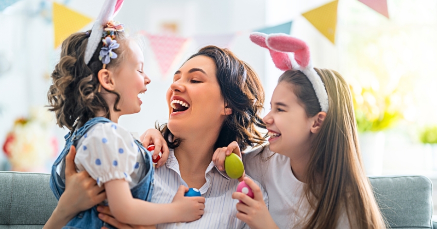 Mãe com duas filhas pequenas celebrando a Páscoa.