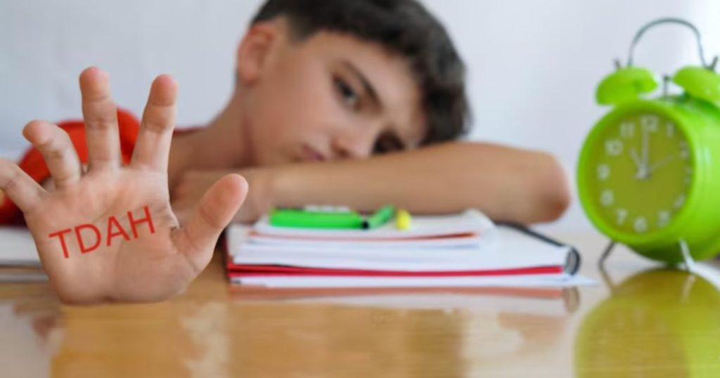Menino de 10 anos com TDAH sentado na mesa com caderno escolar
